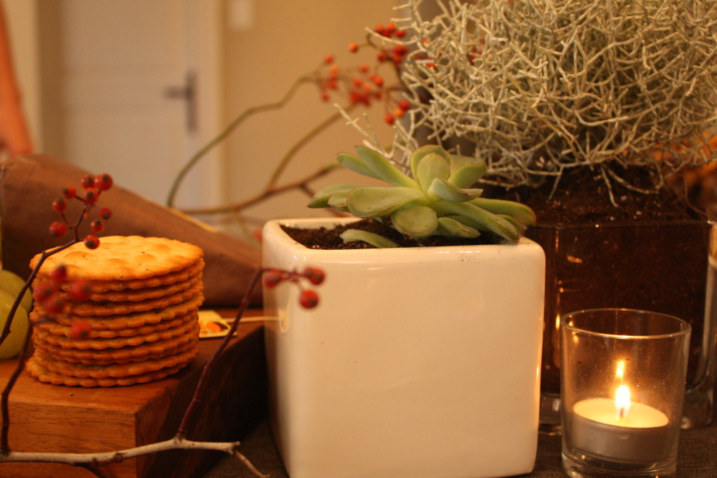 Candles and plants interspersed with the food